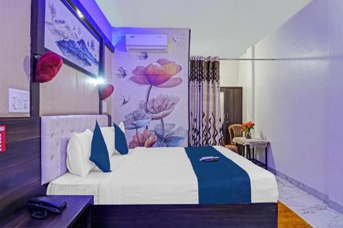 a bedroom with a large bed with a flower mural at Hotel Viraj in Pune