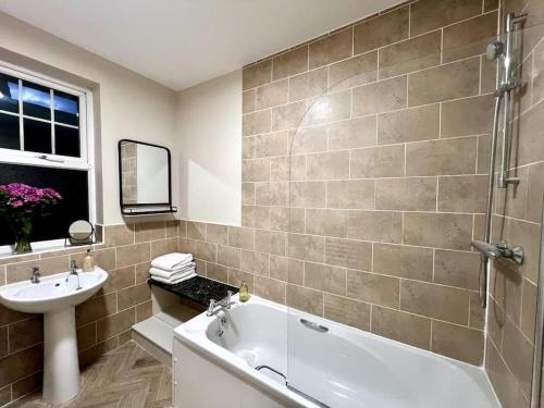 a bathroom with a bath tub and a sink at The Lily•Central Beeston•Private Apartment•SmartTV•Free Wi-Fi•Tram• in Nottingham