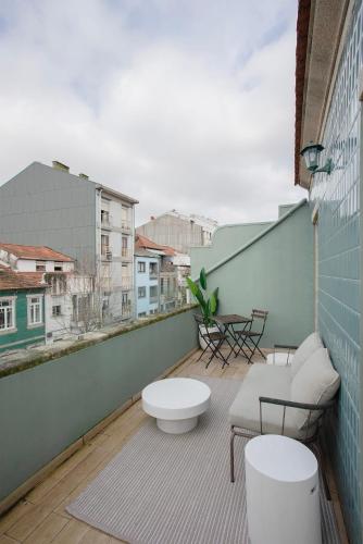 a balcony with a bench and a table on a building at Liiiving in Porto - Downtown Quiet House in Porto