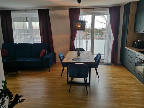 uma sala de estar com uma mesa e um sofá em Apartma Elton em Gornja Radgona
