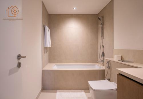 a bathroom with a bath tub and a toilet at Family Apartment with Burj Views at Top Floor 175BC-3 in Dubai