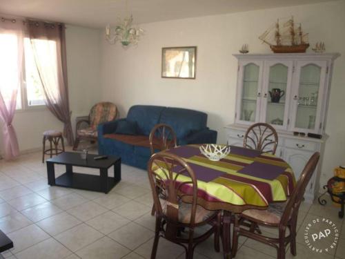 un salon avec une table et un canapé bleu dans l'établissement 80 m de la plage, à Fréjus
