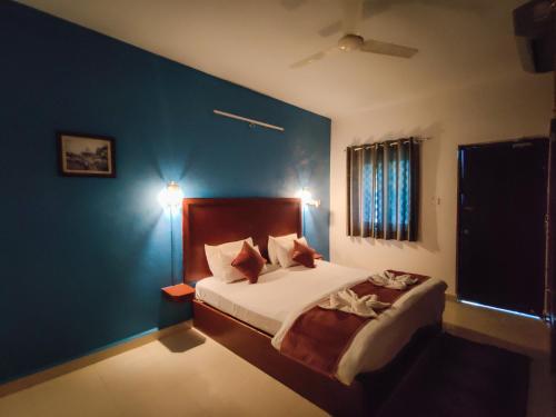 1 dormitorio con cama y pared azul en Vintage Beach Resort, en Agonda