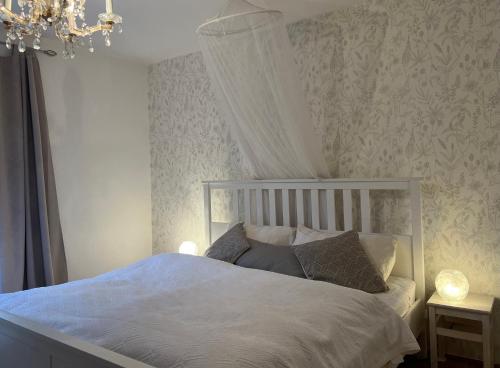 a bedroom with a white bed with a chandelier at Haus mit Garten in Eugendorf