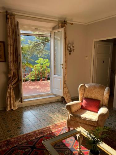 a living room with a chair and an open door at Burlamacchi Villas in Bagni di Lucca