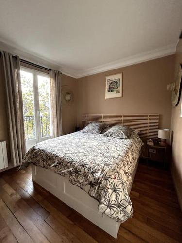 - une chambre avec un lit et une grande fenêtre dans l'établissement Appartement 2 chambres à 10 min de Paris, tout confort, à Clichy