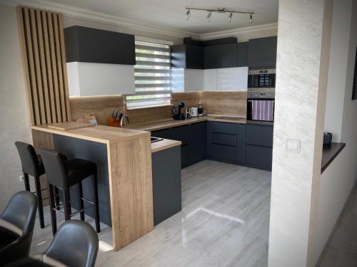 a kitchen with blue cabinets and a bar with stools at Villa Sunrise with swimming pool in Sarajevo
