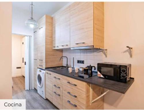 a kitchen with wooden cabinets and a microwave at Apartamento Mar in Aguadulce