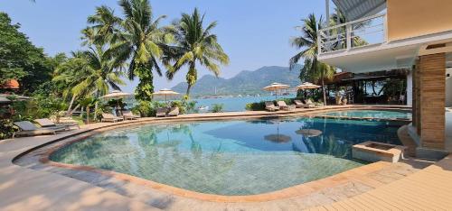 a swimming pool in a resort with a view of the water at Resolution Resort in Ko Chang