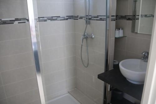 une salle de bain avec douche et lavabo dans l'établissement Appartement 408, Natura beach au village naturiste, au Cap d'Agde
