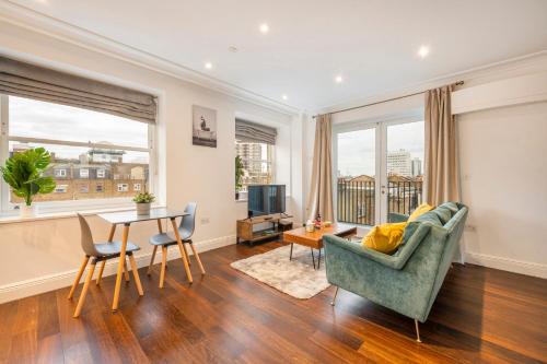 a living room with a couch and a table at Luxury One Bedroom Apartment With AC, Bidet, Balcony View, Free Coffee, Tea, WiFi in Central London in London