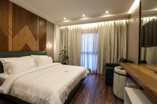 ein Hotelzimmer mit einem Bett und einem TV in der Unterkunft Garden Boutique Hotel in Tirana