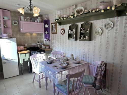 a kitchen with a table and chairs in a room at Memory Lane Farmhouse Carlingford in Lubhaidh