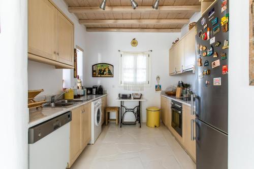 a kitchen with a sink and a refrigerator at Sea View Villa in Ornos in Ornos