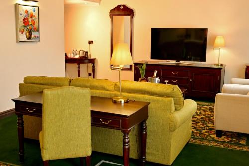 ein Wohnzimmer mit einem Sofa und einem TV in der Unterkunft Midland Hotel Nakuru in Nakuru