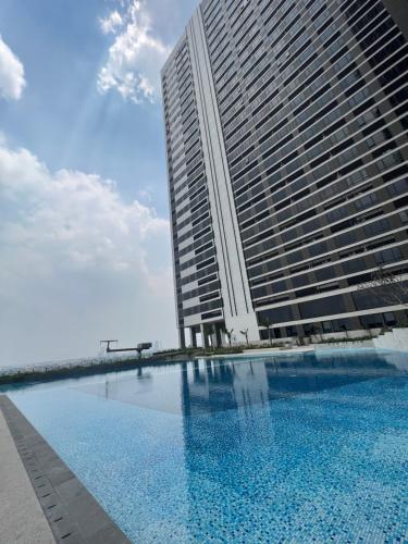 um grande edifício com uma piscina em frente em Newly renovated apartement @ collins boulevard em Warungmangga