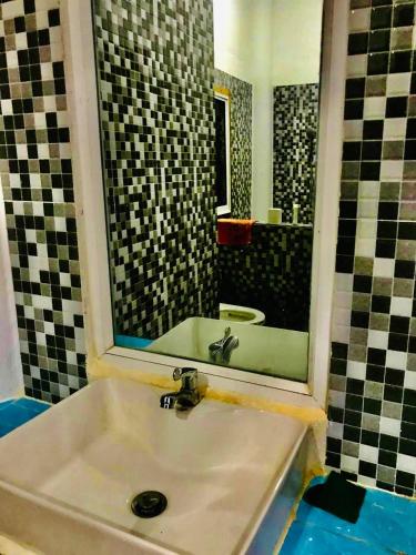 uma casa de banho com um lavatório e um espelho em Brightness Villa (Private Home Stay) em Phumĭ Poŭthĭ Mâ Srei