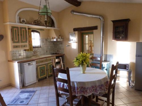 une cuisine avec une table avec un vase de fleurs dessus dans l'établissement BELLEVUE, à Le Tignet