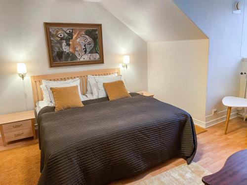 1 dormitorio con 1 cama grande y una pintura en la pared en Anita på Gästis i Anderslöv en Anderslöv