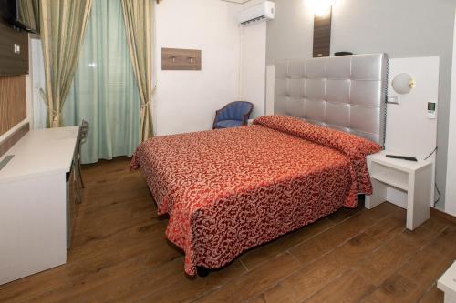 a bedroom with a bed with a red bedspread at Hotel Piola in Milan
