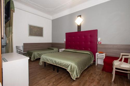 a room with two beds and a red headboard at Hotel Piola in Milan