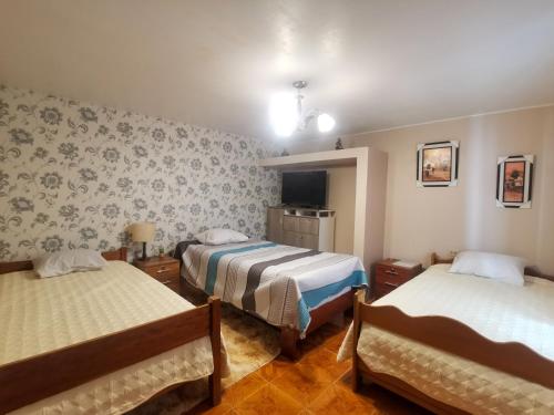 Habitación de hotel con 2 camas y TV en Montafé Mirador, en Tarma