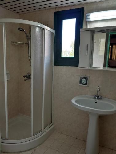 a bathroom with a shower and a sink at Hotel Finiki View in Foinikion