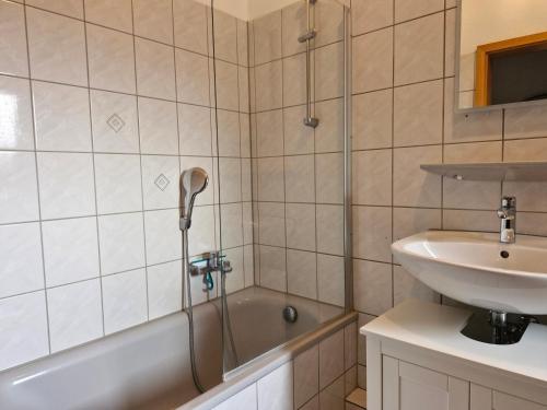 een badkamer met een douche, een wastafel en een bad bij Ferienwohnung Hellmann in Bad Nenndorf