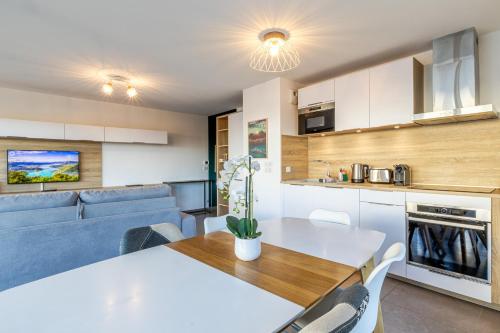 une cuisine et une salle à manger avec une table et des chaises blanches dans l'établissement La Plume Vue Lac 3 étoiles - Garage privé, Secteur recherché, Moderne & tout équipé, 6 personnes, à Annecy