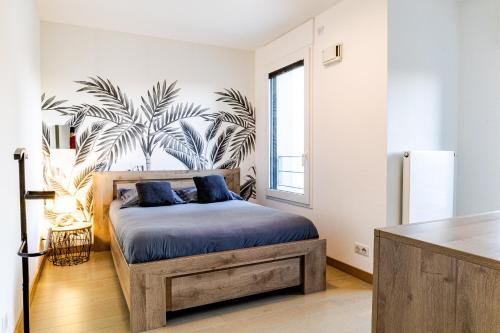 - une chambre avec un lit en bois et des oreillers bleus dans l'établissement La Plume Vue Lac 3 étoiles - Garage privé, Secteur recherché, Moderne & tout équipé, 6 personnes, à Annecy