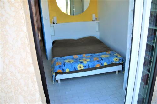 un petit banc dans une pièce avec un miroir dans l'établissement Villa 41, Port Vénus au village naturiste, au Cap d'Agde