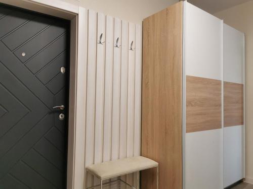 a hallway with a black door and a stool next to a closet at Green Apartments in Chernihiv