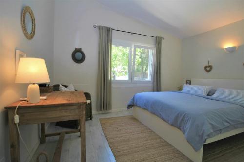 1 dormitorio con cama, escritorio y ventana en Casa Familia - House for 4, en Sa Pobla