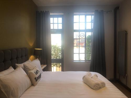 1 dormitorio con 2 toallas en una cama con ventana en Toothbrush Apartments - Central Ipswich - Lloyds Avenue en Ipswich
