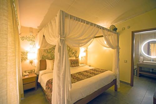 a bedroom with a canopy bed in a room at ONENESS Rishikesh by Ganga Kinare - A Luxury Wilderness Resort in Rishīkesh