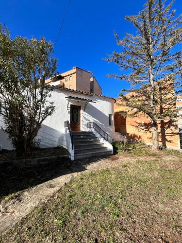 una pequeña iglesia blanca con escaleras y un árbol en Can Bastida, en Cardona