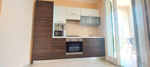 a kitchen with white and brown cabinets and a microwave at Antico Principato di Seborga in Vallebona