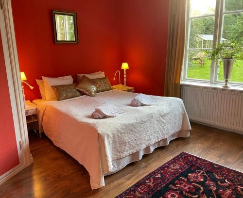 un dormitorio rojo con una cama con dos animales. en Fredriksons Vilt, Vin & Pensionat en Axvall