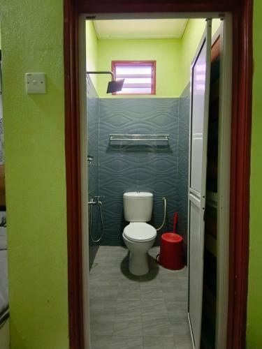 a small bathroom with a toilet and a window at Perhentian Idaman in Perhentian Island