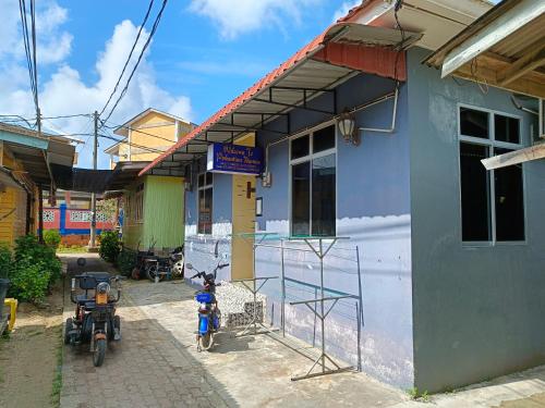 un bâtiment avec deux motos garées devant lui dans l'établissement Perhentian Idaman, aux Îles Perhentian