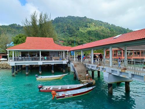 two boats are docked at a pier on the water at Perhentian Idaman in Perhentian Islands