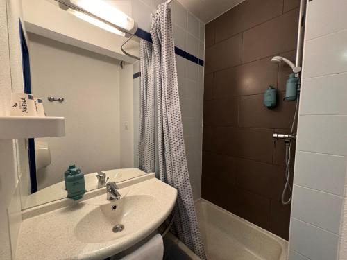 La salle de bains est pourvue d'un lavabo et d'une douche. dans l'établissement Le 2 by Hotel Akena - Nantes Beaujoire, Porte de Sainte Luce, à Sainte-Luce-sur-Loire