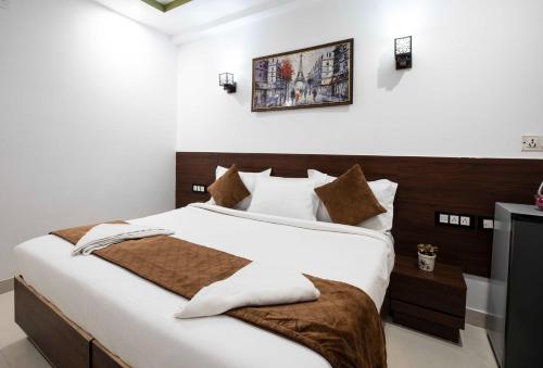 a bedroom with a large bed with a wooden headboard at HR Grand Hotel in New Delhi