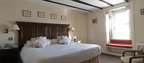 a bedroom with a large bed and a red chair at The Olde Ship Inn in Seahouses