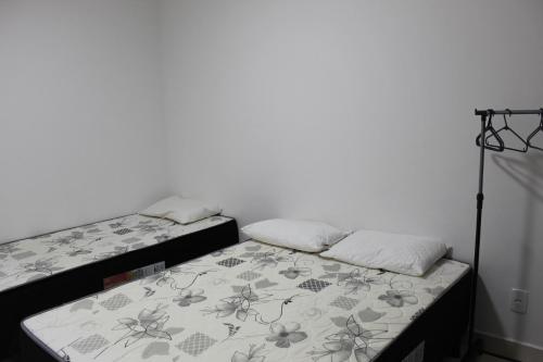 2 Betten nebeneinander in einem Zimmer in der Unterkunft Apt novissimo 3 quartos c elevador a 300m da orla Praia do Morro in Guarapari