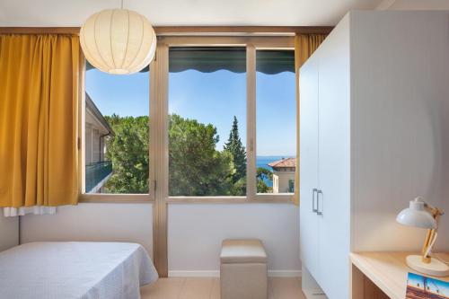 a bedroom with a window with a view of the ocean at Hotel Gabbiano - Garda Lake Collection in Garda