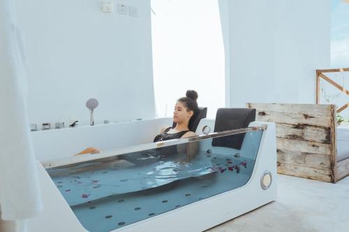 a woman sitting in a bathtub filled with water at Pili Pili Tropical Island in Jambiani