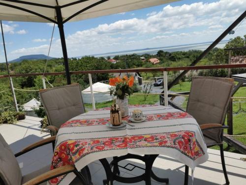 a table with a vase of flowers on a balcony at Jurta Hotel Balatongyörök in Balatongyörök