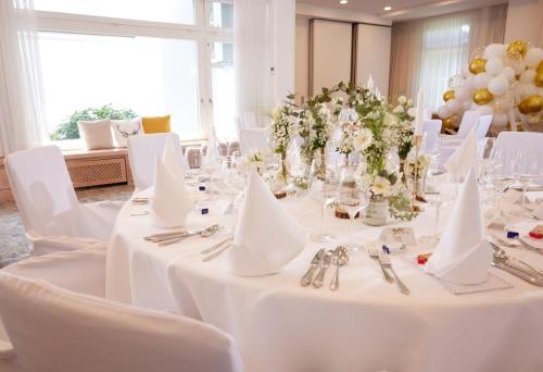 a dining room with white tables and white chairs at Hotel Derichsweiler Hof in Nümbrecht