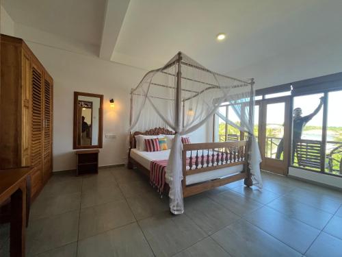 - une chambre avec un lit à baldaquin dans l'établissement Swiss Residenz, à Weligama